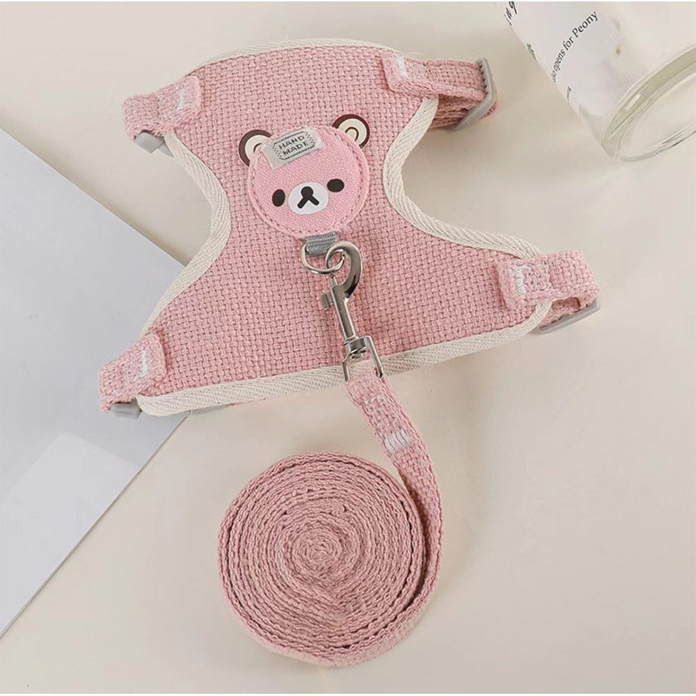 Harnais gilet rose et sa laisse assortie posés sur une table