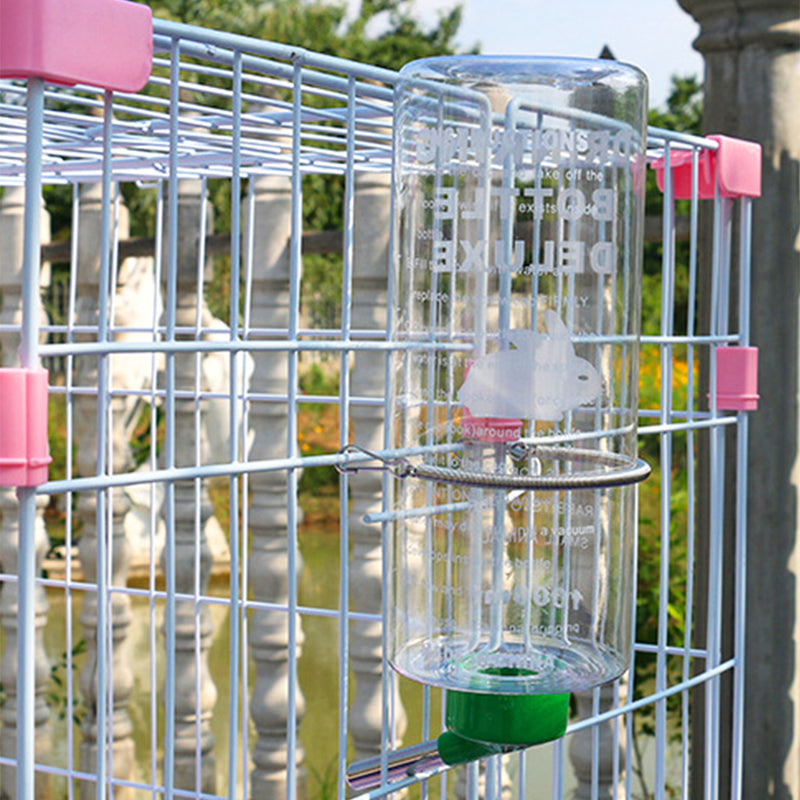 Abreuvoirs suspendus accrochés aux barreaux d'une cage grillagée