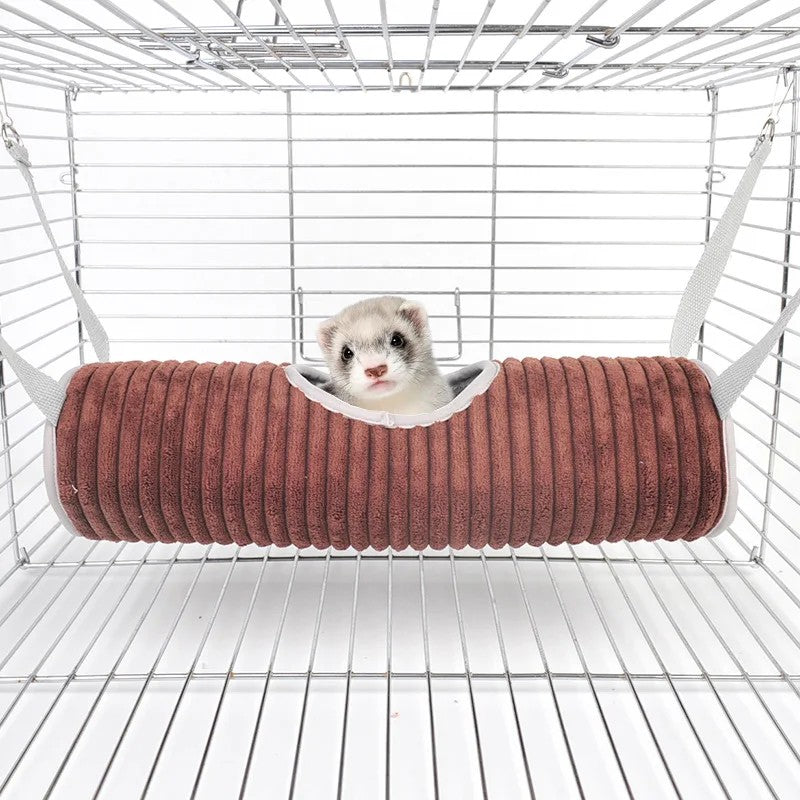 Tunnel-hamac brun accroché aux barreaux d'une cage, un animal installé dans l'ouverture